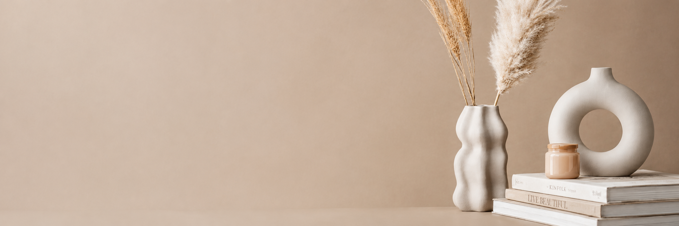 Ceramic vases with dried pampas on stacked books